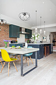 Custom-made concrete table with classic chairs in open kitchen