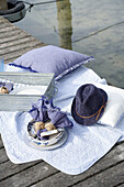 Picnic on the jetty with purple cushions, crockery and hat