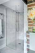 Shower area with glass partition in light grey bathroom