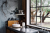 Küchenzeile mit Arbeitsplatte aus Blech und Waschbecken in rustikalem Ambiente