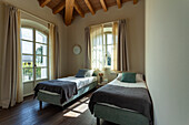 Two single beds in a room with a wooden ceiling