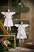 Hanging wooden angel decoration on a rustic wall