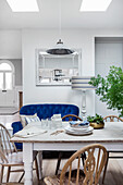 White painted wooden table and chairs in the dining area with skylight