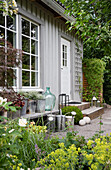 Zinc pots, balloon bottle, and watering cans in front of the guest house with gravel terrace