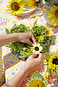Making heart wreath from sunflower blossoms and buds