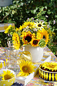 Sonnenblumenstrauß auf Tisch mit Kuchen im Freien