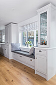 Built-in window seat with storage drawers in a bright kitchen