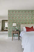 Spacious bedroom, room dividing wall with wallpaper