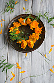 Kranz aus Ringelblumen (Calendula), Blüten auf Teller