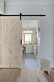 View through open wooden barn sliding door into the kitchen