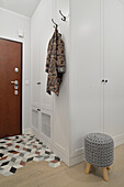 White built-in closets with coat hooks in the hallway
