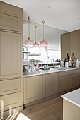 Elegant beige kitchen with mirrored wall