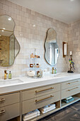 Elegant bathroom with long washbasin and two organically shaped wall mirrors
