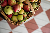 Apples in a basket on chequered wooden floor
