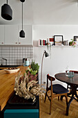 Küchentheke mit Holzarbeitsplatte und kleiner Essbereich mit Vintage Stühlen in offenem Wohnraum