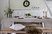 Festive and Christmassy dining table with candles and wreath on the wall