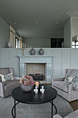 Comfortable armchairs and coffee table in front of the fireplace