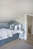 Single bed in the attic room in blue and white tones