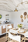 Small kitchen, sunny dining area and collection of hats in the wooden cottage
