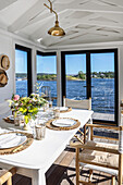 Sunny dining area with sea view in the wooden cottage