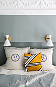 Throw pillows on double bed, wall lights above