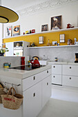 Light-colored kitchen with cooking island, yellow stripe on the wall