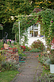 An allotment garden in autumn with an arbour under the trees