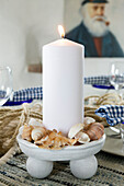 DIY-Kerzenschale mit Muscheln und weißer Stumpenkerze