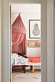Bed with crocheted bedspread and canopy in girl's room