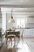 Bright eat-in kitchen with round table, chairs and built-in bench
