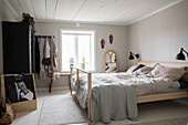 Bright bedroom with double bed, antique wardrobe and black and white photo