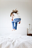Mädchen springt auf Bett