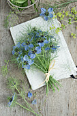 Bouquet of Love in the Mist (Nigella) and lady's mantle (Alchemilla) on linen cloth