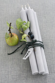 Four candles, with sloe branch, apple, and name tag