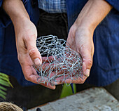 Crumpled wire mesh around plant stems to support the flower arrangement