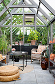 Cosy seating area in the greenhouse with plants