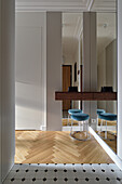 Hallway area with floor-to-ceiling mirrors, console and stool