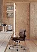 Integrated built in desk with leather chair in room with wooden elements