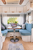 Sitzecke mit hellblauen Auflagen im Wohnwagen
