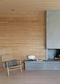 Seating area in front of wood paneled wall and fireplace with a concrete wall