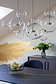 Pendant light with glass globes above dining table