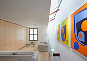 Lounge on the upper floor with skylight and modern art