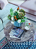 Circular coffe table with ornate vase and flowers