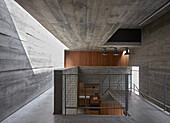 Staircase landing with metal balustrade in a concrete house