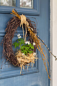Wreath with wood anemone (Anemone nemorosa) and palm catkins by the door