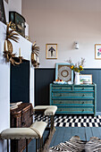 Turquoise blue dresser and decorative fireplace with chest and mantelpiece in the living room