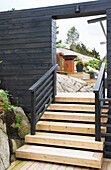 External staircase leads to the passageway with black-painted wooden wall, patio entrance