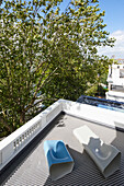 View of tiled roof terrace with designer loungers