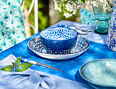 Blau-weißes Gedeck auf einem Sommertisch im Freien