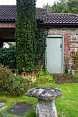 Idyllic garden with ivy-covered brick cottage